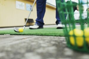 Low section of man playing golf at driving range